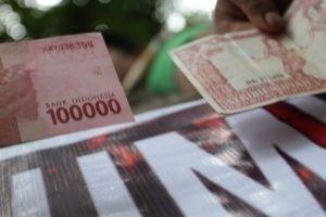 Yogoy/Massa GAPAI Sumut menunjukkan lembaran uang yang diduga berisi lambang komunis