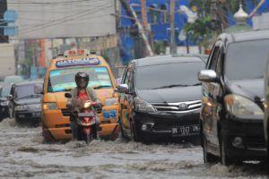 Yogoy/Seorang pengendara motor ikut terjebak banjir bersama sejumlah mobil 