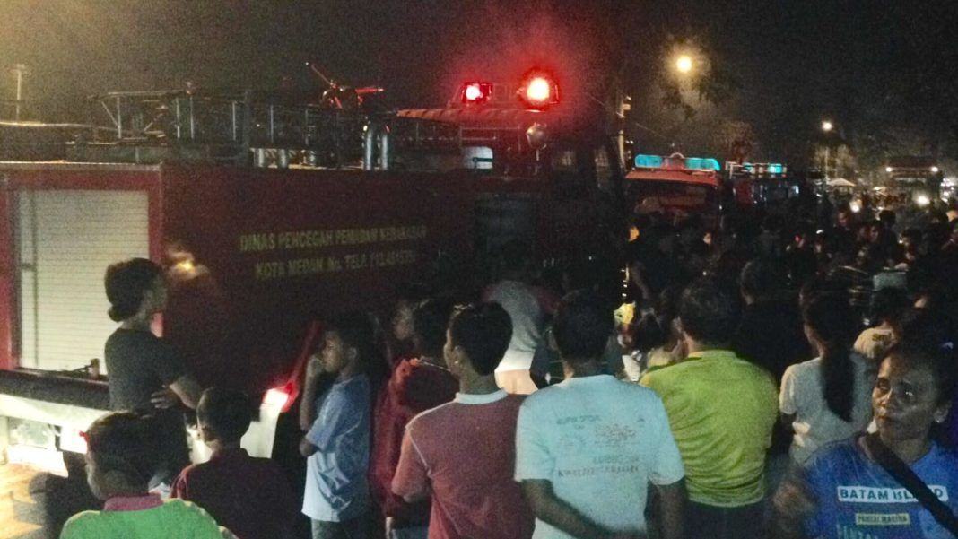 Warga Padati lokasi kebakaran saat petugas pemadam kebakaran berusaha memadamkan api