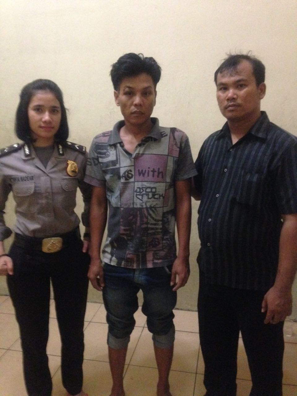 Tersangka (tengah) diapit kedua petugas setelah diamankan di Polsek Sunggal