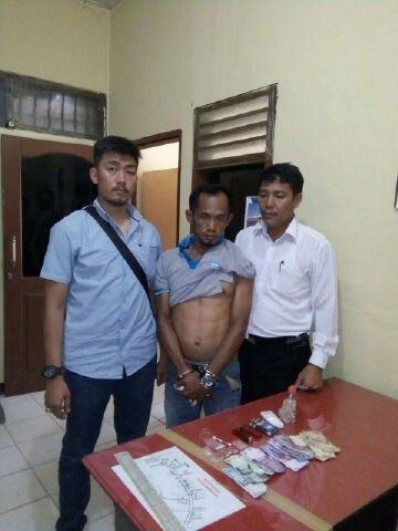 Salah satu tersangka diapit personel Polsek Indra Pura