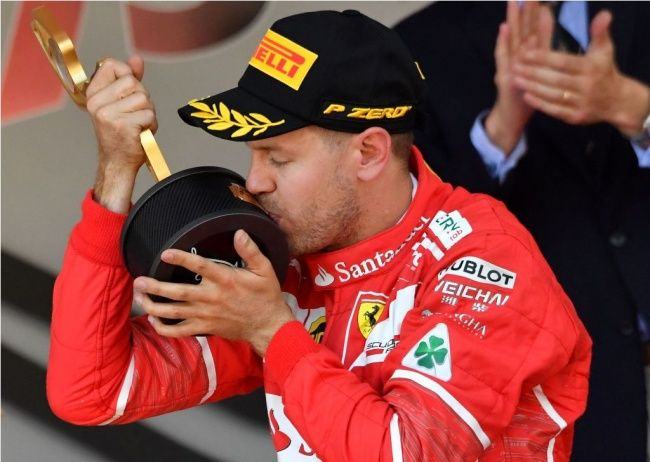 Sebastian Vettel mencium trofi juara GP F1 Monaco (AFP Photo: Pascal Guyot)