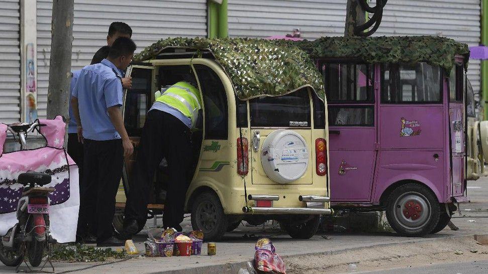 Foto: Polisi memeriksa miniatur kendaraan di sebuah taman kanak-kanak di Fengxian, Provinsi Jianshu, China, Jumat (16/6). Kemarin, sebuah ledakan keras terjadi di gerbang TK tersebut dan menewaskan delapan orang. (AFP PHOTO / GREG BAKER)