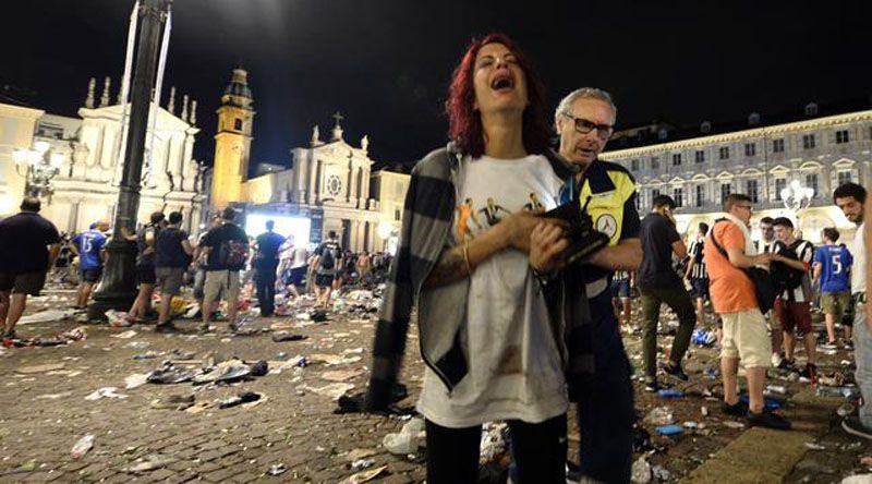 Petasan dengan daya ledak besar membuat kepanikan fans Juventus yang sedang nonton bareng menggunakan layar lebar di San Carlo Square. (AFP)
