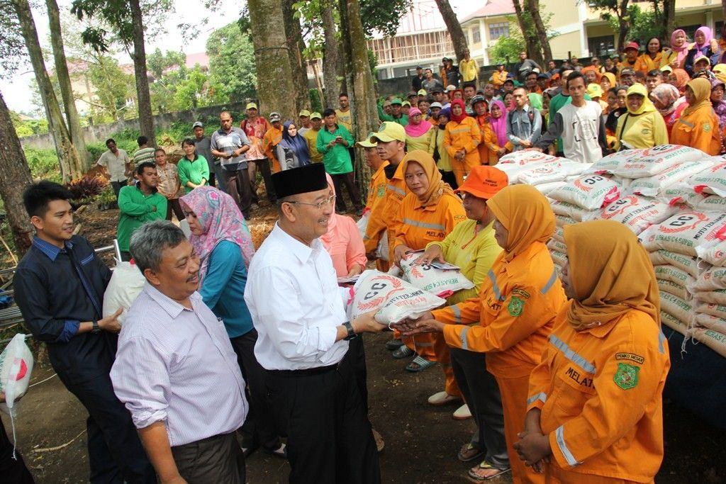 Foto: Walikota Medan Drs H T Dzulmi Eldin S MSi membagikan sembako untuk 1.500 petugas kebersihan lapangan baik Melati maupun Bestari Dinas Kebersihan dan Pertamanan Kota Medan di Lapangan Cadika Pramuka Jalan Karya Wisata Medan, Kamis (22/6) siang.