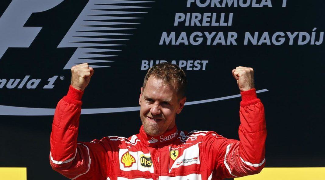 Pembalap Ferrari, Sebastian Vettel, rayakan kemenangan GP Hungaria di Sirkuit Hungaroring, Minggu (30/7). (AP Photo/Darko Bandic)