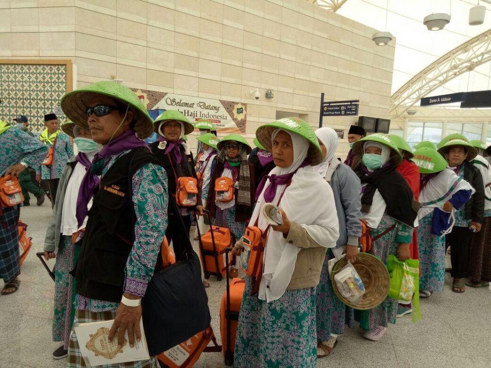 Foto: Jemaah kloter 45 Embarkasi Solo (SOC 45) tiba di terminal haji sambil memakai caping, Jumat (11/8).