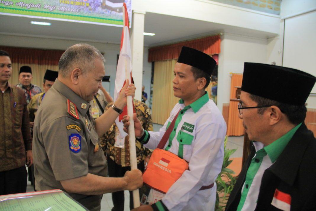 Foto: Kepala Satuan Polisi Pamong Praja (Satpol PP) Asren Nasution menyerahkan Pataka Merah Putih di Aula I Madinatul Hujjaj Asrama Haji Medan.