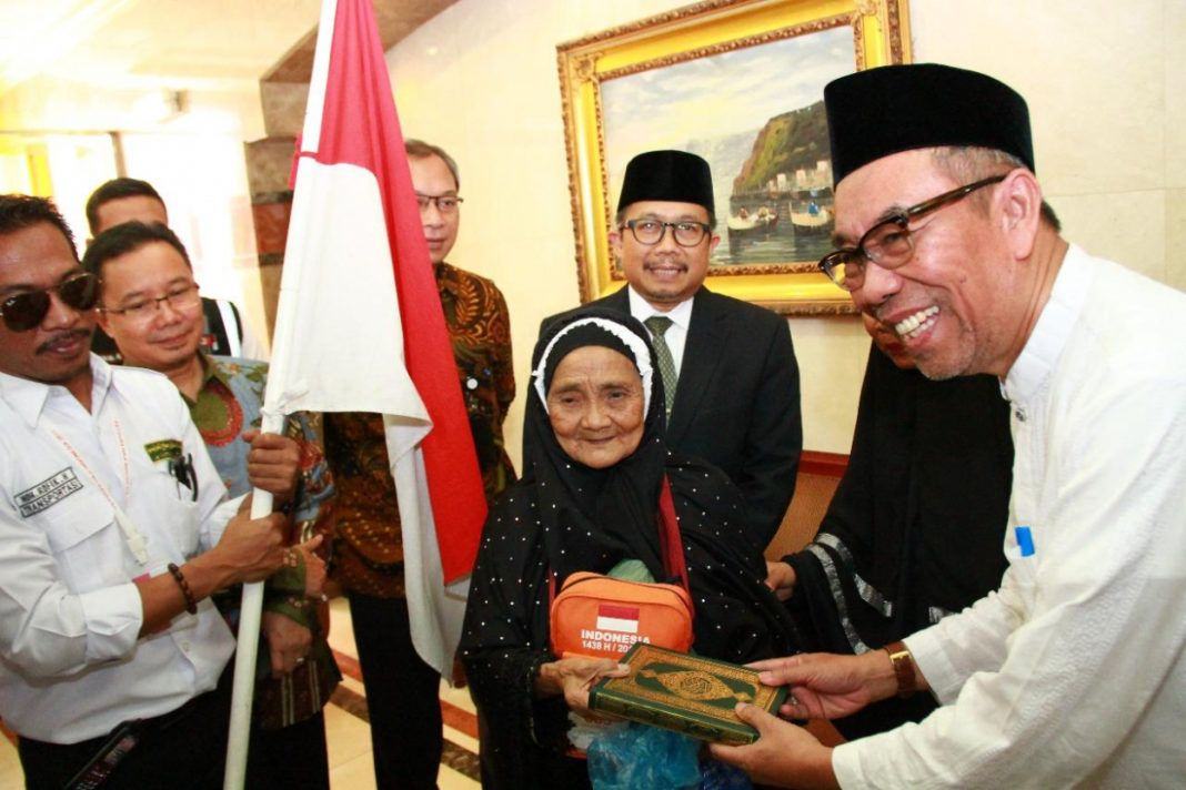 Foto: Sekjen Kemenag Nur Syam serahkan Al Quran kepada Jemaah Tertua saat pelepasan kloter terakhir.