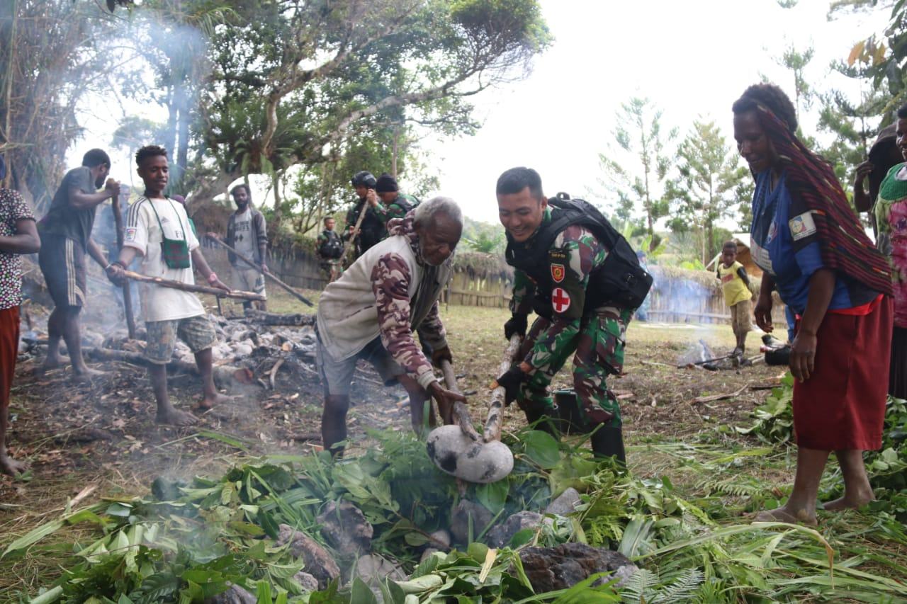 Satgas Pamtas Yonraid 323/BP/13/1 Kostrad, Bakar Batu Tingkatkan Silaturahmi