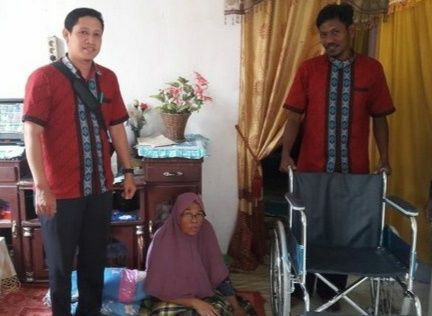 Syahrun SHI yang didampingi staf Baitul Mal kota langsa bapak Jul menyalurkan satu kursi roda kepada warga.