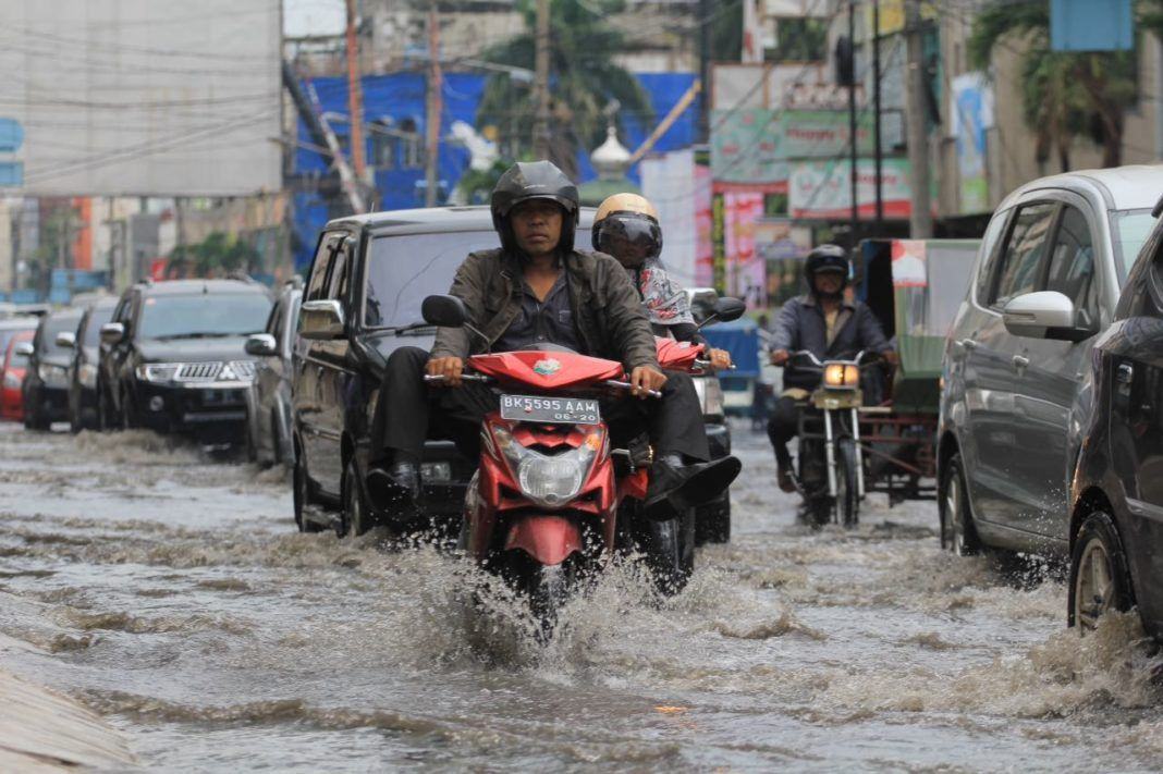 Yogoy/Seorang pengendara motor terlihat kesulitan melewati banjir
