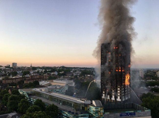Asap dan api menyelimuti sebuah apartemen bertingkat 27 lantai yang terbakar di London (14/6). Gedung apartemen tersebut terbakar mulai dari lantai dua hingga puncak bangunan. (Foto: AFP).