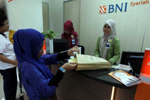 Foto: Petugas bank BNI Syariah melayani nasabah.