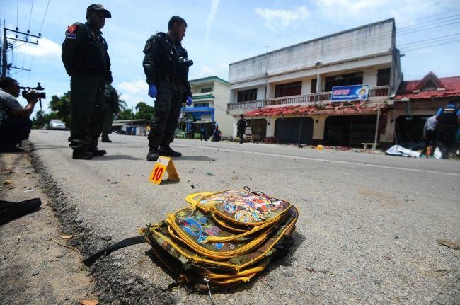 Sebuah tas sekolah anak-anak tergeletak di jalanan saat petugas memeriksa lokasi ledakan bom di distrik Tak Bai, Thailand, 6 September 2016. (Foto: AFP/MADAREE TOHLALA)