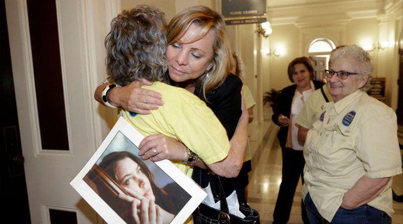 Debbie Ziegler memegang foto putrinya Brittany Maynard yang telah meninggal setelah kebijakan hak untuk hidup dideklarasikan dan disetujui oleh Majelis Negara Bagian di Sacramento, California (AP)