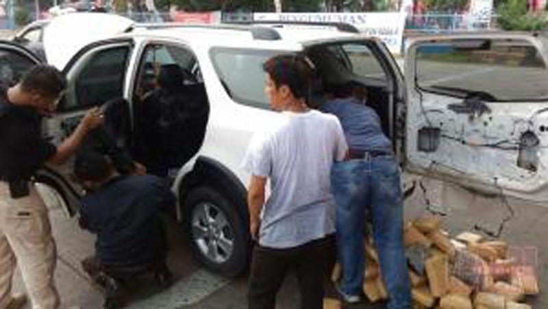 Foto: Polisi membongkar isi kendaraan yang ditemukan ratusan paket ganja.