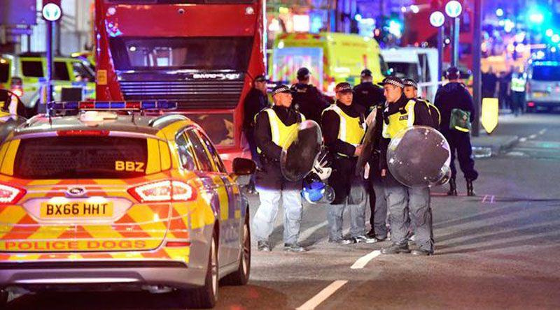 Polisi dengan perisai anti huru hara di Borough High Street setelah teror di London tengah, Sabtu (3/6). Serangan teror terjadi di London Bridge dan Borough Market, yang dilakukan lima orang pria. (AP Photo/ Matt Dunham).