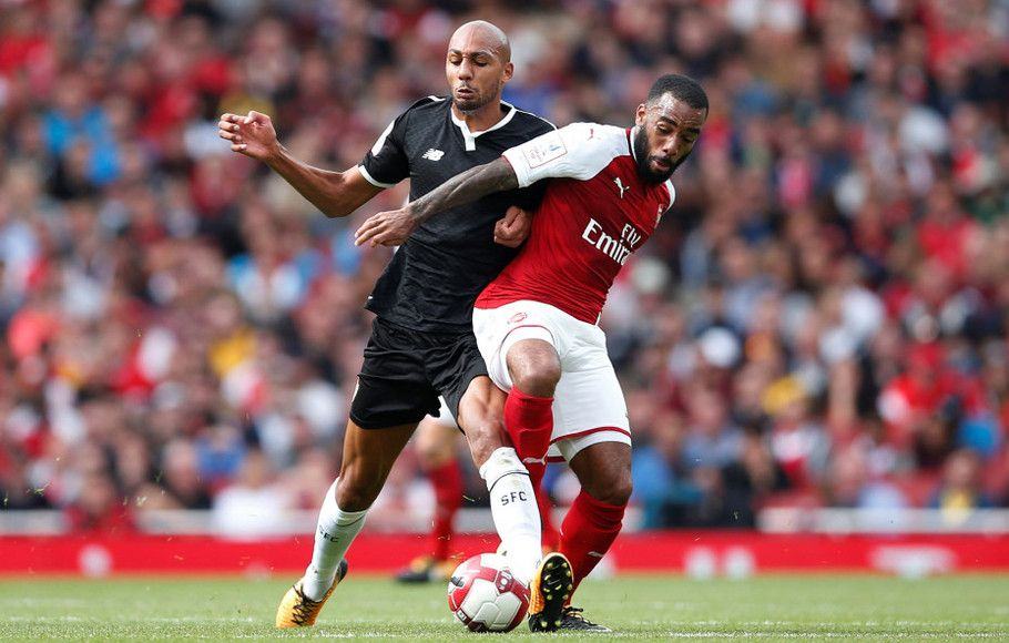 Penyerang Arsenal, Alexandre Lacazette (kanan) terlibat duel dengan gelandang Sevilla, Steven N'Zonzi dalam laga uji coba pramusim Piala Emirates, Minggu (30/7). (AFP)