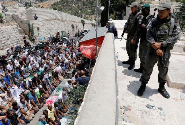 Pasukan Israel lakukan penjagaan di depan warga Muslim yang melakukan Salat di Gerbang Singa, Yerusalem (Foto: EPA).