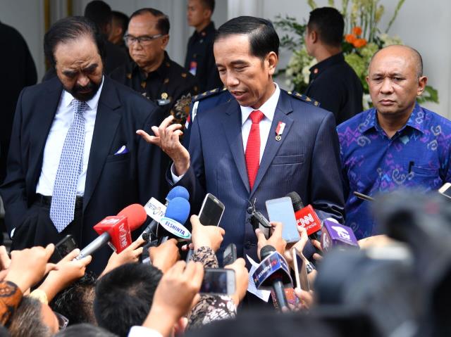 Presiden Jokowi menjawab pertanyaan wartawan seusai memberikan kuliah umum pada pendidikan Akademi Bela Negara Partai Nasdem di Jakarta, Minggu (16/7)