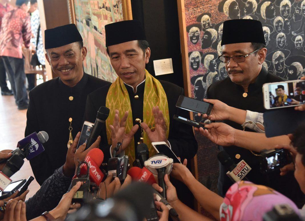 Presiden Jokowi menjawab pertanyaan wartawan usai menghadiri Lebaran Betawi X, yang diselenggarakan di Pusat Perkampungan Budaya Betawi, di Setu Babakan, Jakarta Selatan, Minggu (30/7).