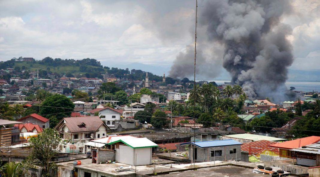 Asap hitam membumbung tinggi ke udara usai militer pemerintah Filipina melancarkan serangan udara ke sebuah lokasi yang telah dikuasai oleh militan Maute di kota Marawi, Filipina Selatan, (27/5). (AP Photo / Bullit Marquez)
