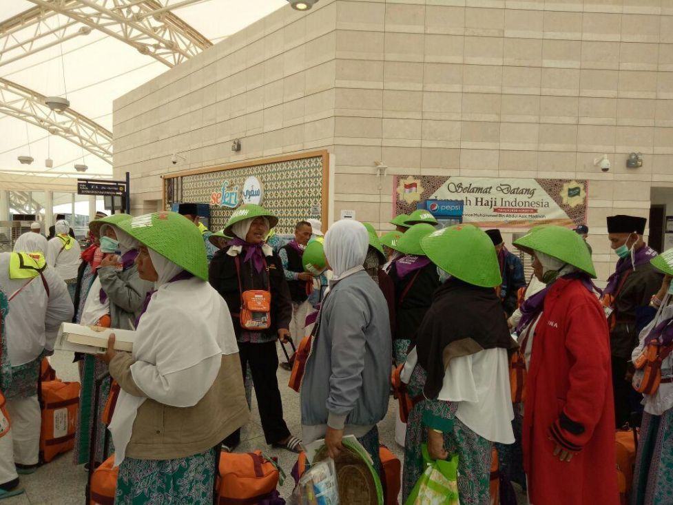 Foto: Jemaah kloter 45 Embarkasi Solo (SOC 45) tiba di terminal haji sambil memakai caping, Jumat (11/8).