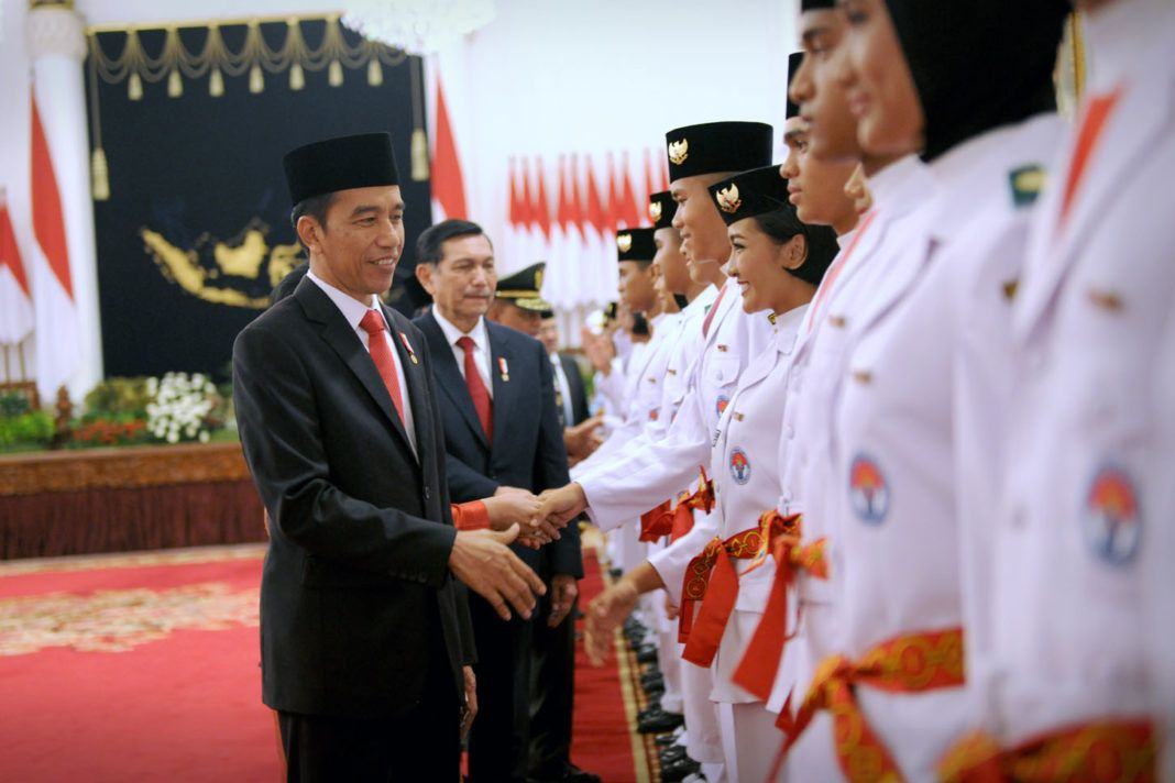 Foto: Presiden Jokowi memberikan selamat kepada Paskibraka yang telah dikukuhkan di Istana Negara, Jakarta, Selasa (15/8).
