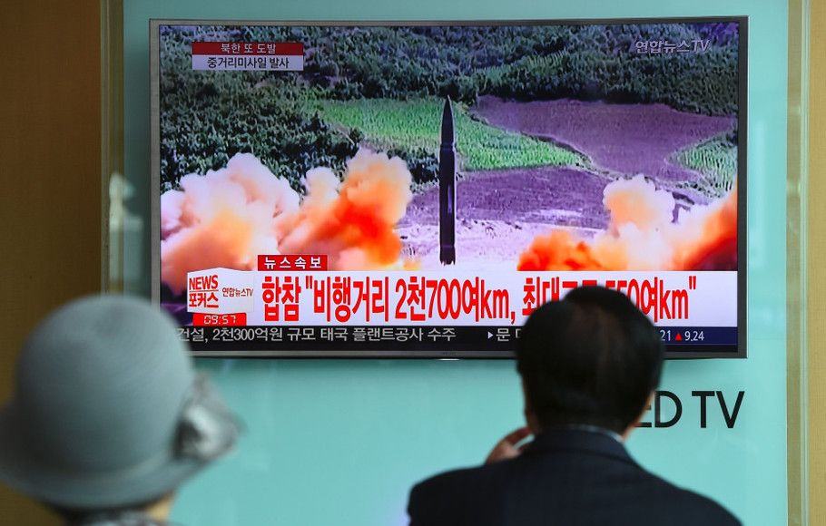 Warga menyaksikan penembakan rudal Korea Utara yang disiarkan televisi. (AFP)