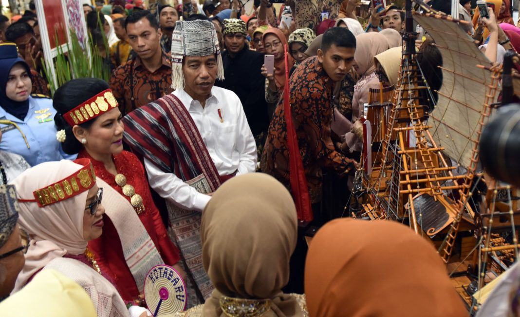 Foto: Dengan mengenakan baju adat, Presiden Jokowi didampingi Ibu Negara Iriana berdialog dengan para pengrajin usai membuka Pameran Kriyanusa Dekranas,di JCC, Jakarta, Rabu (27/9).