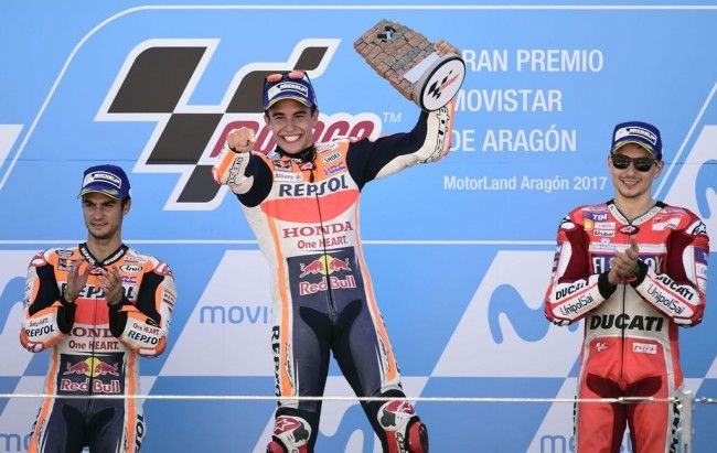 Marc Marquez merayakan kemenangan MotoGP Aragon di podium juara. (AFP PHOTO / JOSE JORDAN)