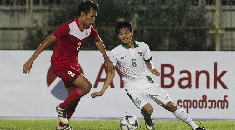 Gelandang Timnas Indonesia U-19, Muhammad Iqbal, berebut bola dengan pemain Filipina U-19 pada laga Piala AFF U-18 di Stadion Thuwanna, Myanmar, Kamis (7/9). Indonesia menang 9-0 atas Filipina. (AFP/Ye Aung Thu)