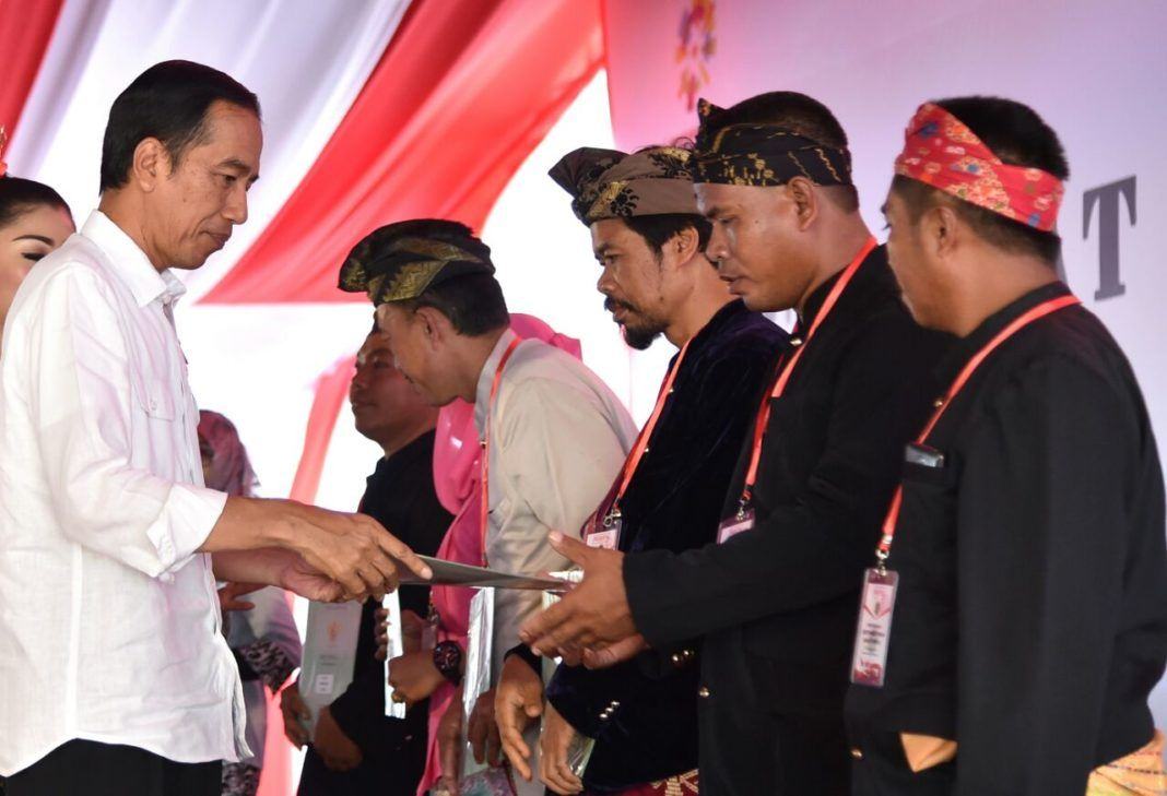 Foto: Presiden Jokowi menyerahkan sertifikat kepada perwakilan masyarakat di lapangan Masjid Nurul Bilad, Kawasan Ekonomi Khusus (KEK) Mandalika, Kab. Lombok Tengah, NTB, Jumat (20/10)
