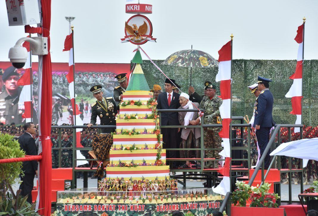 Foto: Presiden Jokowi melihat tumpeng pada perayaan HUT ke-72 TNI, di Dermaga Indah Kiat Cilegon, Provinsi Banten, Kamis (5/10).