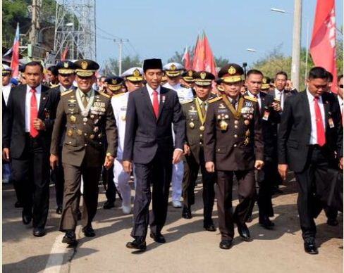 Foto: Presiden Jokowi didampingi Panglima TNI dan Kapolri berjalan kaki menuju lokasi HUT ke-72 TNI, di dermaga Indah Kiat Cilegon, Banten, Kamis (5/10) pagi.